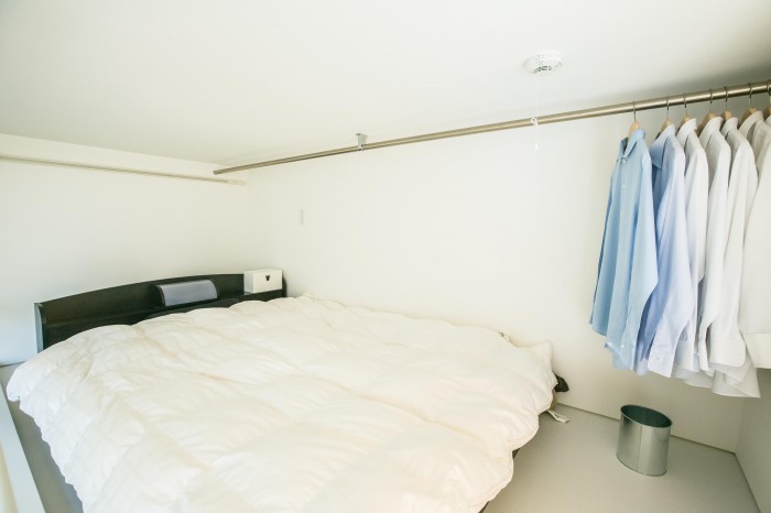 ロフトの上はシンプルなベッドルーム空間。潔い色使いは白、収納されているのにインテリアの一部のようなシャツ。